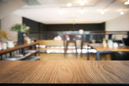 Empty wooden table in front of abstract blurred background of coffee shop . can be used for display or montage your products.Mock up for display of product