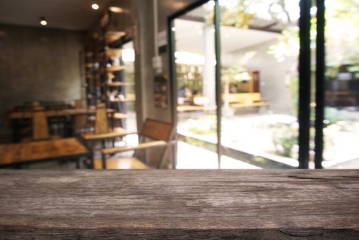 Empty wooden table in front of abstract blurred background of coffee shop . can be used for display or montage your products.Mock up for display of product