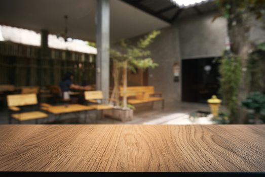 Empty wooden table in front of abstract blurred background of coffee shop . can be used for display or montage your products.Mock up for display of product