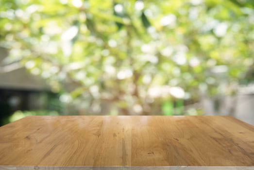 image of wooden table in front of abstract blurred background of outdoor garden lights. can be used for display or montage your products.Mock up for display of product