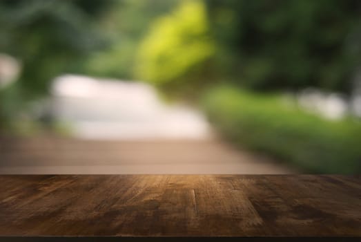 Image of wooden table in front of abstract blurred background of outdoor garden lights. can be used for display or montage your products.Mock up for display of product.