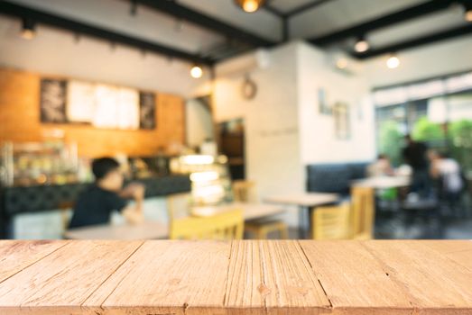 Empty wooden table in front of abstract blurred background of coffee shop . can be used for display Mock up  of product.