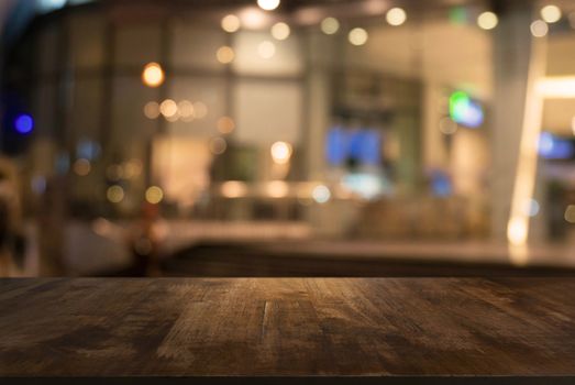 Empty wooden table in front of abstract blurred background of coffee shop . can be used for display Mock up  of product.