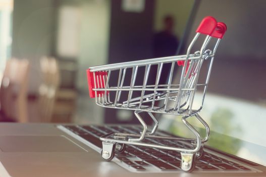 Small shopping cart with Laptop for shopping online concept.
