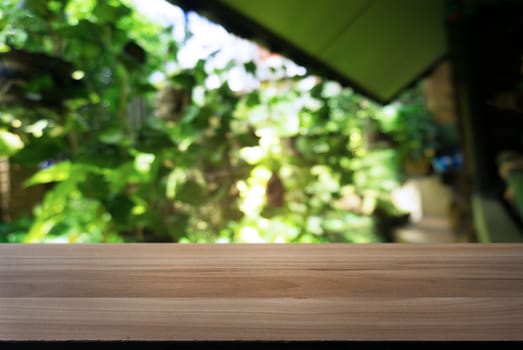 Image of wooden table in front of abstract blurred background of outdoor garden lights. can be used for display or montage your products.Mock up for display of product.