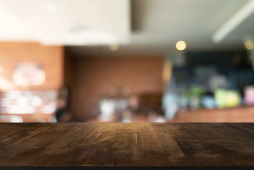 Empty wooden table in front of abstract blurred background of coffee shop . can be used for display Mock up  of product.