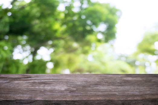 Image of wooden table in front of abstract blurred background of outdoor garden lights. can be used for display or montage your products.Mock up for display of product.