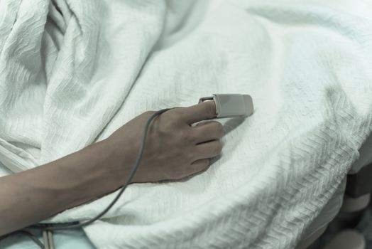 Vintage tone close-up pulse oximeter in a lady patient fingertip for heart rate and blood oxygen level monitoring at labor and delivery room
