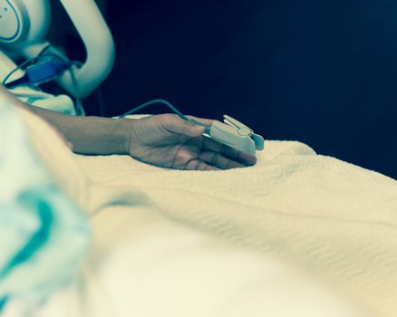 Vintage tone close-up pulse oximeter in a lady patient fingertip for heart rate and blood oxygen level monitoring at labor and delivery room