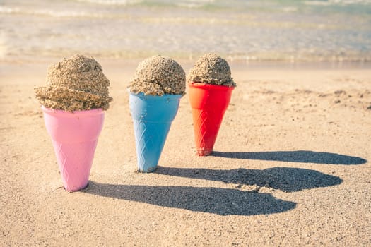 Colorful sand cones in the sand on the beach,summer concept,used split toning for vintage style.