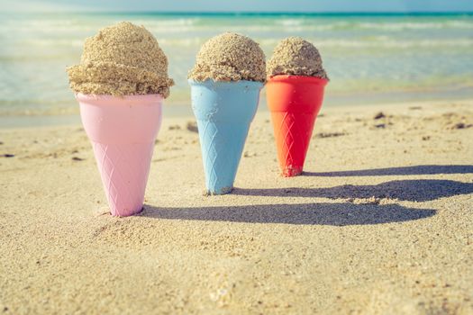 Colorful sand cones in the sand on the beach,summer concept,used split toning for vintage style.