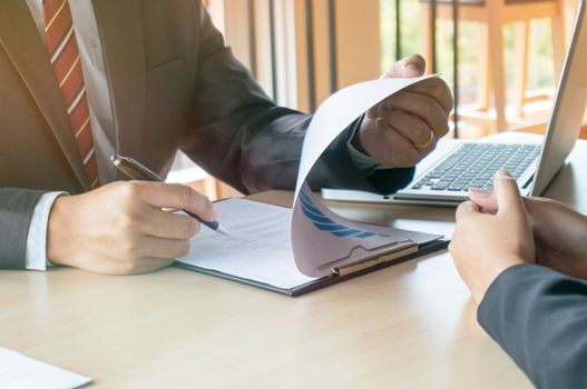 View of a Examiner reading a resume during a job interview.