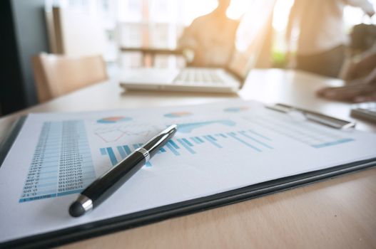 Financial graph with a pen on table in office. business concept.