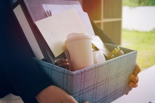 Business woman moving offices packing up Cardboard Box in office