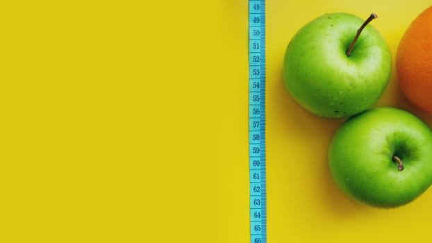 A green apple with measurements isolated on a yellow background. fitness food.