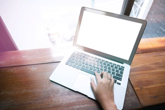 Casual business woman working by using a laptop computer on wooden table. Hands typing on a keyboard.