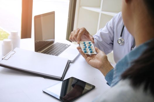 Doctor hand holding pack of different tablet blisters for patient. prescribe medicament.  disease healing concept.