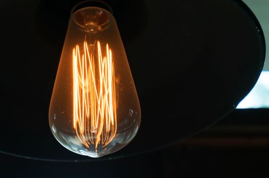 Decorative antique edison style light bulbs against black background.