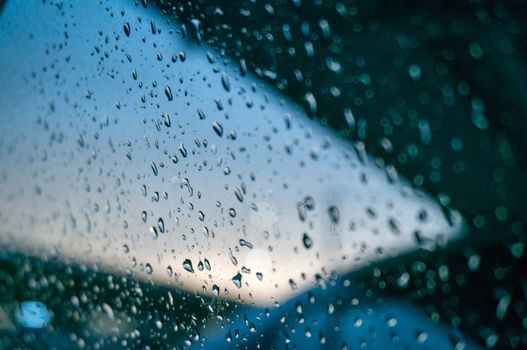 Rain drops on window glasses surface with city view selective focus