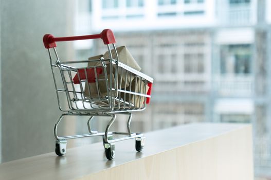 Shopping cart full of cardboard Paper boxes. Trolley with gifts The concept of shopping. Selective focus.