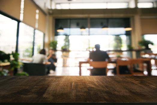 Empty wooden table in front of abstract blurred background of coffee shop . can be used for display or montage your products.Mock up for display of product.