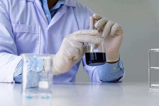 Male medical or scientific laboratory researcher performs tests with blue liquid in laboratory. equipment science experiments concept