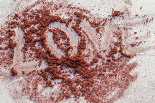 The word love is written on a loose powder makeup, white background.