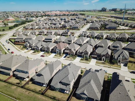 Top view new established neighborhood suburban Dallas, Texas, USA. Row of single-family houses with gardens near elevated highway viaduct