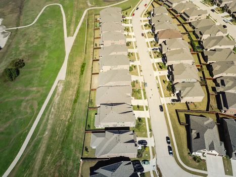 Top view new established neighborhood with brand new houses near park and pathway trail. Flyover residential area in suburban Dallas, Texas, USA