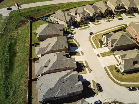 Aerial view new development community with row of detached single-family house and garden. Flyover residential area suburban Dallas, Texas, USA