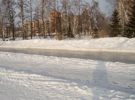 Winter landscape of the open city Park with ice skating track.