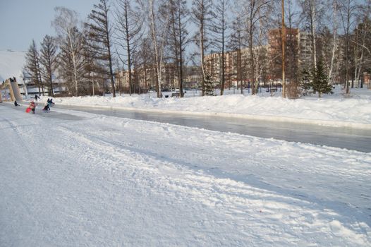 Winter landscape of the open city Park with ice skating track.