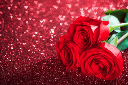 Red rose flowers on glitter hearts bokeh background with copy space Valentine day concept