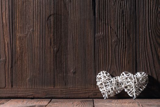 White wicker hearts on old wooden background Valentine day