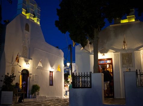 traditional narrow street in Mykonos with blue doors and white walls