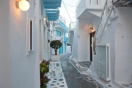 traditional narrow street in Mykonos with blue doors and white walls