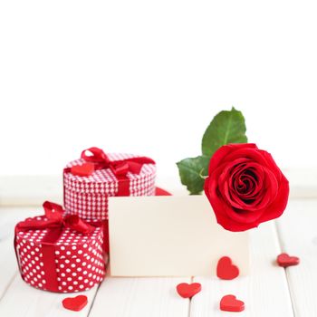 Red rose, heart and blank card on wooden table, valentines day concept