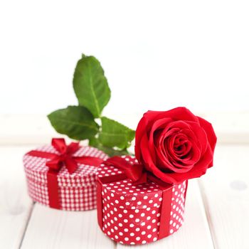 Valeintines day gifts and red rose on wooden table isolated on white background