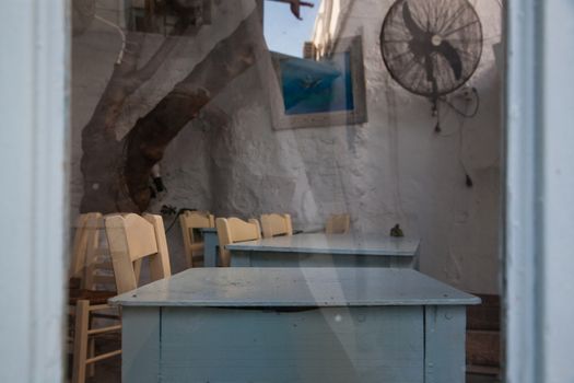 traditional narrow street in Mykonos with blue doors and white walls