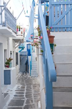 traditional narrow street in Mykonos with blue doors and white walls