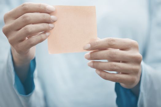 Hand of human holding adhesive note with copy space