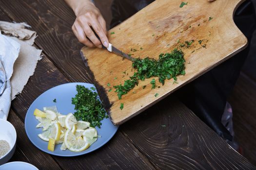 Woman cutting culinary plants and vegetables