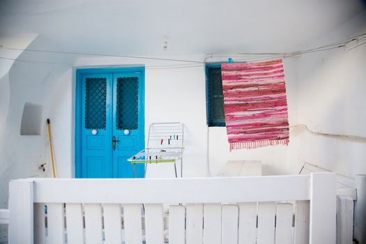 traditional narrow street in Mykonos with blue doors and white walls