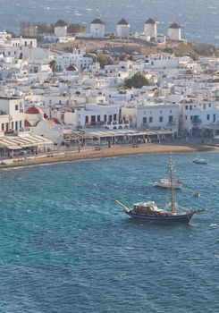 panoramic view of the Mykonos town harbor with famous windmills from the above hills on a sunny summer day, Mykonos, Cyclades, Greece 