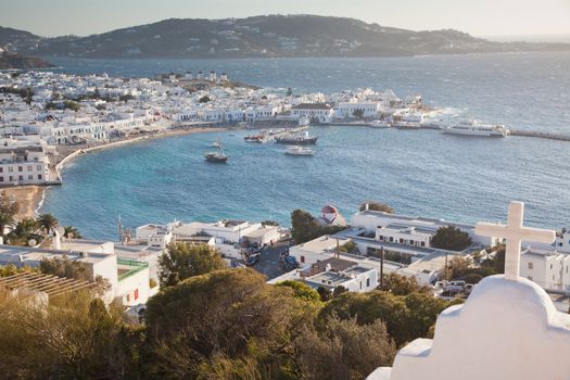 panoramic view of the Mykonos town harbor with famous windmills from the above hills on a sunny summer day, Mykonos, Cyclades, Greece 