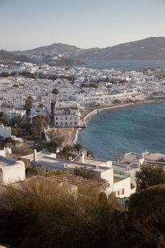 panoramic view of the Mykonos town harbor with famous windmills from the above hills on a sunny summer day, Mykonos, Cyclades, Greece 