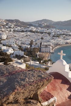 panoramic view of the Mykonos town harbor with famous windmills from the above hills on a sunny summer day, Mykonos, Cyclades, Greece 