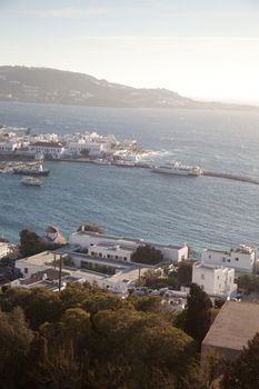 panoramic view of the Mykonos town harbor with famous windmills from the above hills on a sunny summer day, Mykonos, Cyclades, Greece 