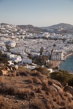 panoramic view of the Mykonos town harbor with famous windmills from the above hills on a sunny summer day, Mykonos, Cyclades, Greece 