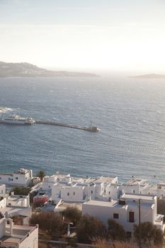 panoramic view of the Mykonos town harbor with famous windmills from the above hills on a sunny summer day, Mykonos, Cyclades, Greece 